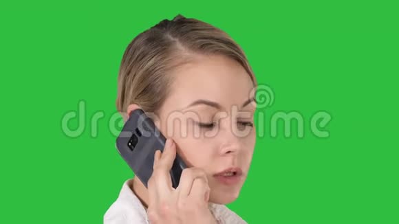 金发女人在绿色屏幕上用手机说话Chroma键视频的预览图