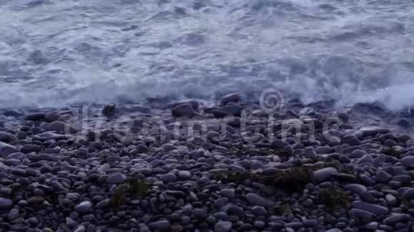 蓝色的海水撞击海滩上的鹅卵石视频的预览图