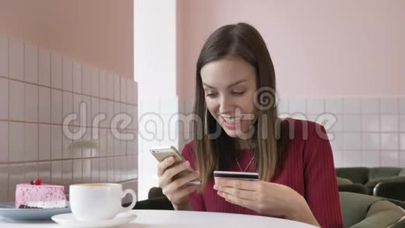 漂亮的女人在家里用智能手机用信用卡在线购物生活方式漂亮的女孩看着摄像机视频的预览图