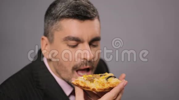 饥肠辘辘的上班族吃着开胃的奶酪披萨男人享受快餐视频的预览图