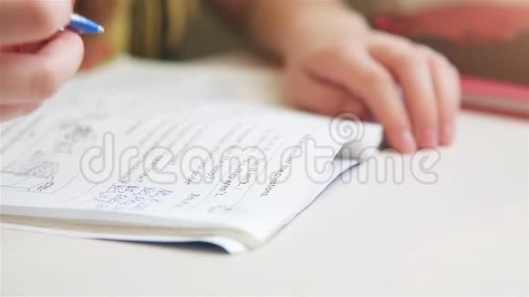 坐在桌旁的女孩用英语写笔记本作业视频的预览图
