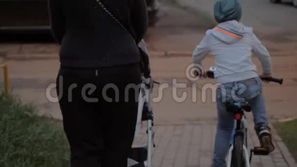 母亲带着两个孩子在街上骑自行车的大男孩视频的预览图