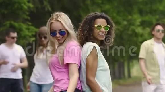 美丽的多元文化的朋友在公园里跳舞笑迪斯科夏天视频的预览图