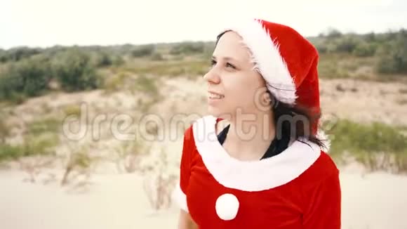 一个在沙漠里打扮成圣诞老人的女孩新年假期旅游的概念新年快乐圣诞快乐视频的预览图