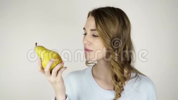 漂亮的头发女人咬着梨舔着嘴唇视频的预览图