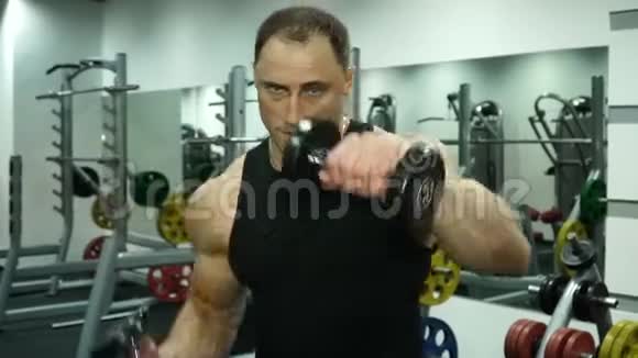 一个手里拿着哑铃的肌肉拳击手正在进行打击视频的预览图