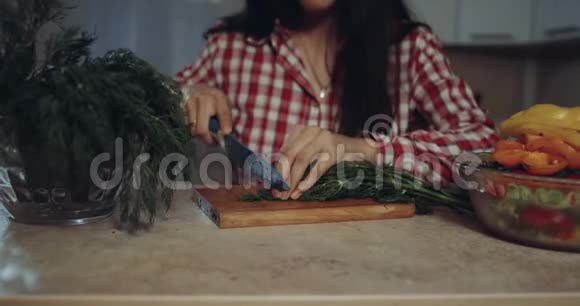 年轻女子准备切菜做食物视频的预览图