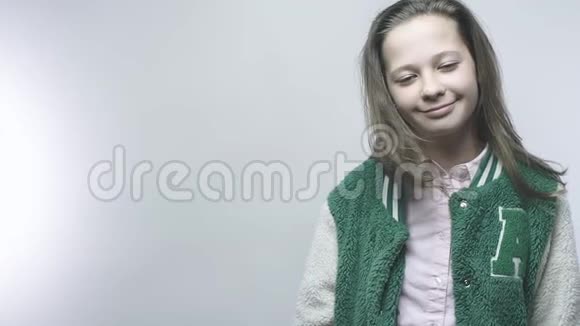 美丽的女孩穿着红色夹克闭着眼睛放松和微笑镜头拍摄了学校女生的全景视频的预览图