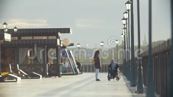 坐在轮椅上的残疾人在码头上和女朋友一起打电话视频的预览图
