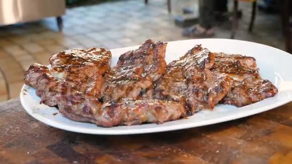 油炸的肉躺在白色的盘子里放出蒸汽准备好的肉排在上桌前先撒上盐餐厅视频的预览图