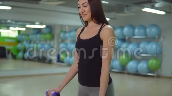 健身理念年轻女运动员在体育馆里用哑铃训练视频的预览图