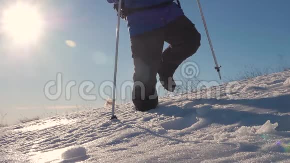 徒步旅行者在冬天寒冷的雪天徒步旅行在山脉的背景下腿沿着山脊走视频的预览图