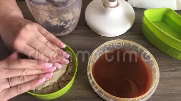 一个女人把蜂蜜切碎的花生和种子的混合物密封在一个容器里为了塑造哈尔瓦视频的预览图