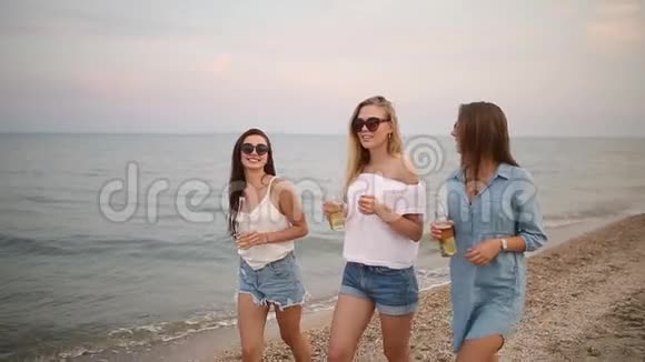 一群女性朋友在日落时分在海边的海滩上慢动作享受饮料青年妇女视频的预览图