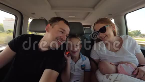 快乐的父母带着大儿子和小女儿开车旅行视频的预览图