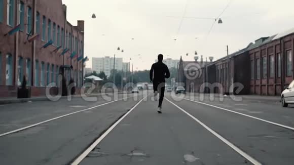 沿着一条老城区街道跑步的人后视图在通往成功和实现目标的路上对比拍摄视频的预览图