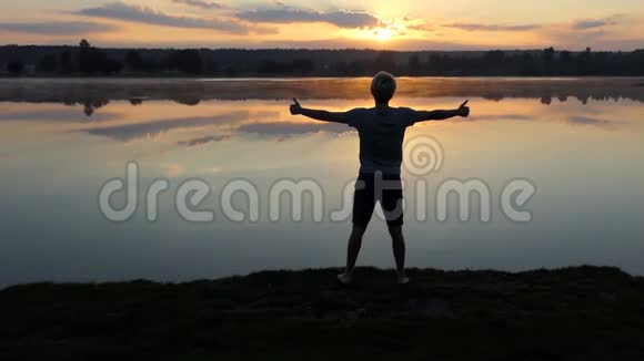 太阳落山时一个虔诚的人竖起两个大拇指视频的预览图