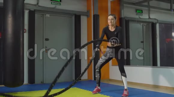 年轻女孩的慢动作与健身房里的绳索接触视频的预览图