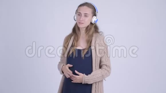 年轻美丽的孕妇听音乐视频的预览图