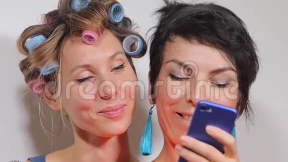两个女孩看着智能手机的屏幕视频的预览图