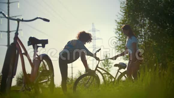 一个年轻的骑自行车的人弯着腿背景是女孩在喝水视频的预览图