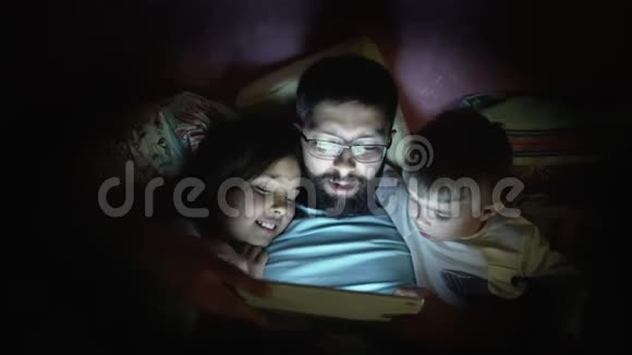 父亲带着小孩在睡觉前上网视频的预览图