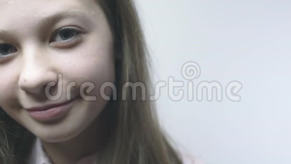 微笑的小女孩的特写肖像潘从相机从右向左缓慢运动视频的预览图