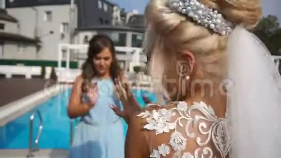 迷人的新娘在游泳池附近和伴娘跳舞时玩得很开心结婚纪念日视频的预览图