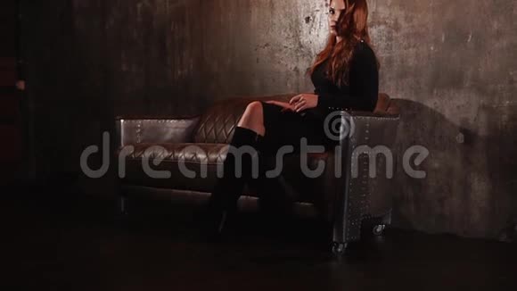 坐在一张皮沙发上的红发美女视频的预览图