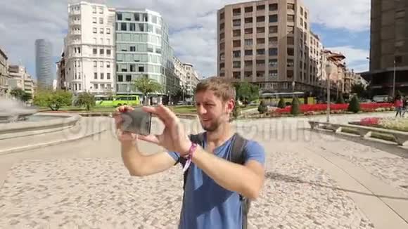 青年游客使用智能手机拍摄360度全景视频的预览图