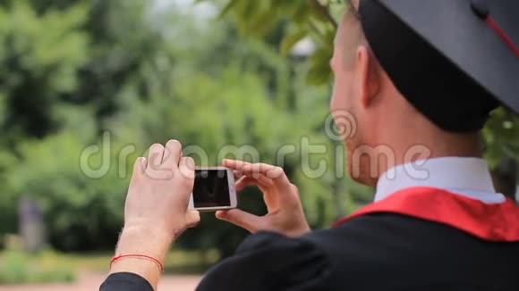 男生在智能手机上给朋友拍照并竖起大拇指视频的预览图