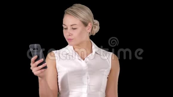 年轻女孩从手机屏幕上读到阿尔法频道视频的预览图