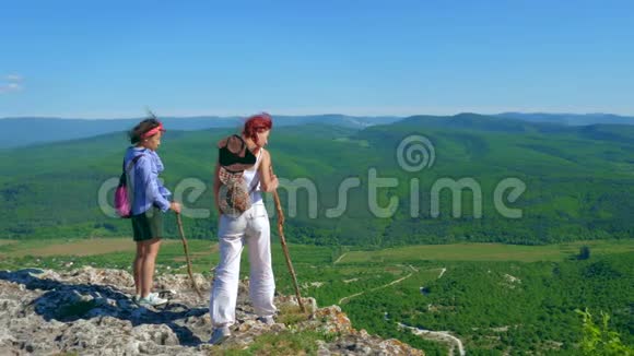 两个女旅行家的女朋友走在高原上欣赏美丽的景色视频的预览图