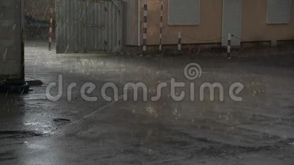雨滴落在沥青上缓慢地在建筑物附近拍摄视频的预览图