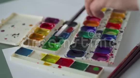 画笔从调色板中提取不同颜色的水彩颜料并将其混合视频的预览图