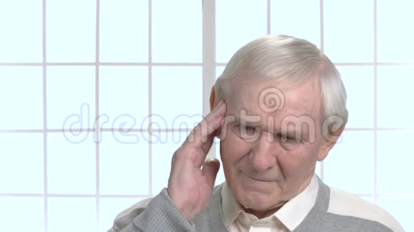 无精打采的老人摸着他的太阳穴视频的预览图