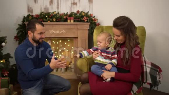 一家人一起庆祝圣诞节快乐妈妈爸爸和小宝宝坐在房间里过圣诞节视频的预览图