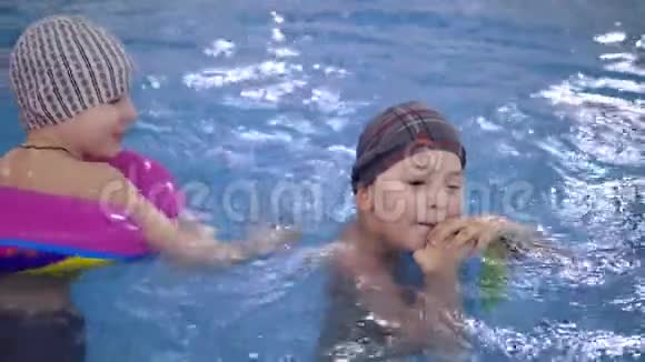 孩子们在游泳池里水上游戏小孩子在游泳池里洗澡视频的预览图