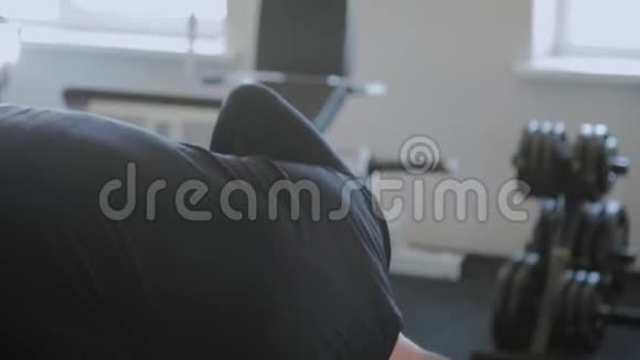 一个超重的成年男子在健身房里做过度伸展运动视频的预览图