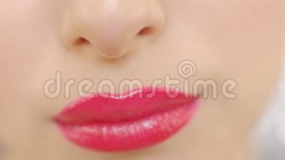 特写女人嘴唇上涂着红色口红完美的嘴唇性感的嘴巴闭上年轻时灿烂的笑容视频的预览图