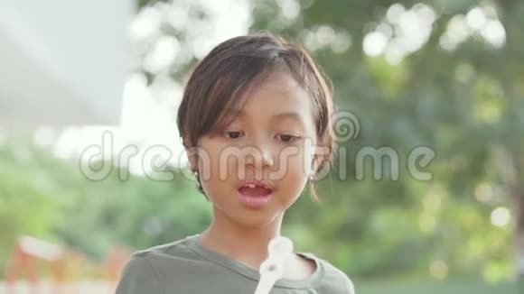 可爱的小女孩在户外吹肥皂泡视频的预览图