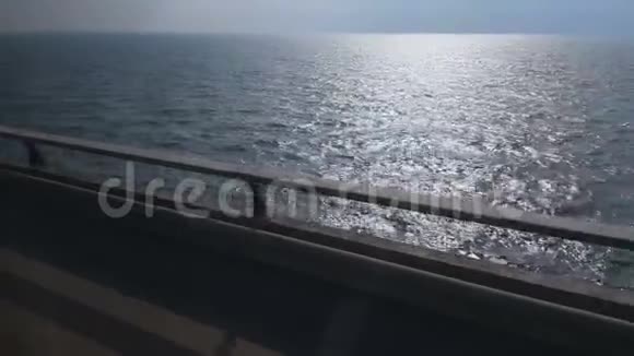 在靠近蓝海的道路上行驶在海岸线上行驶平静的水面上行驶视频的预览图