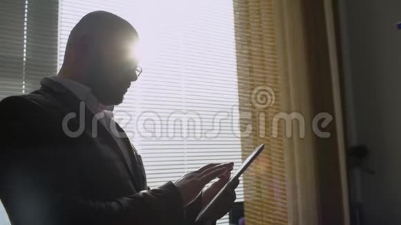 商人在办公室窗户附近做数字平板电脑使用数字平板电脑的人视频的预览图