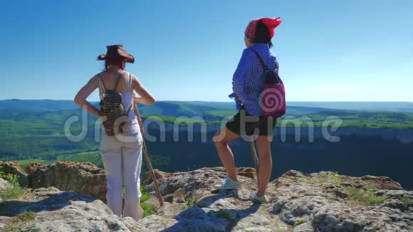 两个女旅行家的女朋友走在高原上欣赏美丽的景色视频的预览图