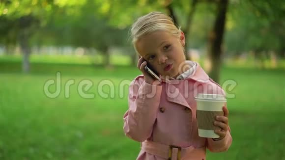 可爱的小女孩穿着粉红色的衣服走着电话视频的预览图