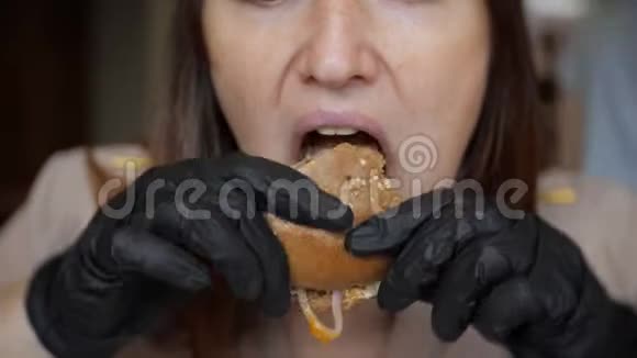 把戴黑手套的漂亮女孩关起来在咖啡馆里吃汉堡视频的预览图