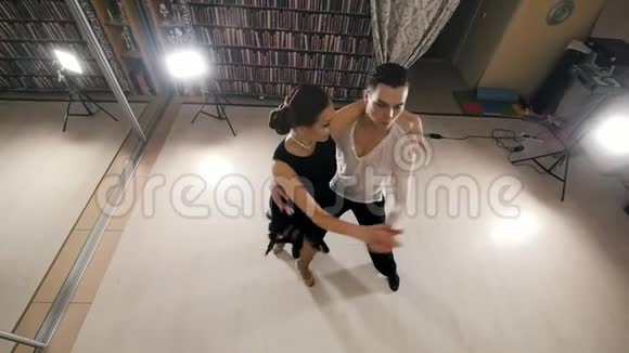 年轻迷人的男人和女人在工作室里穿着服装跳舞和排练拉丁美洲舞蹈俯视缓慢视频的预览图