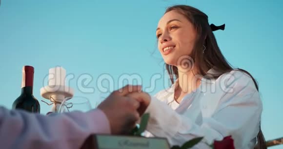 美丽的微笑的女人正在与她的爱人交谈并在户外浪漫晚餐期间牵手4K录像视频的预览图
