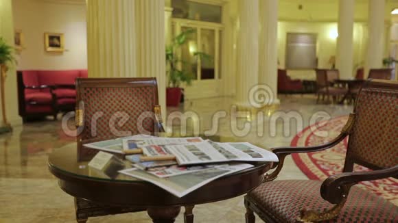 穿着休闲服的商人在酒店大堂阅读当地新闻出差视频的预览图