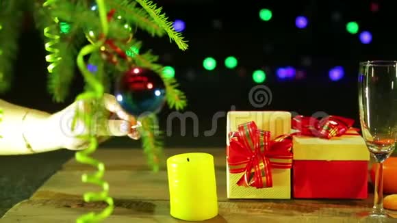 女性手在圣诞礼物和香槟酒杯旁边的桌子上点燃蜡烛视频的预览图